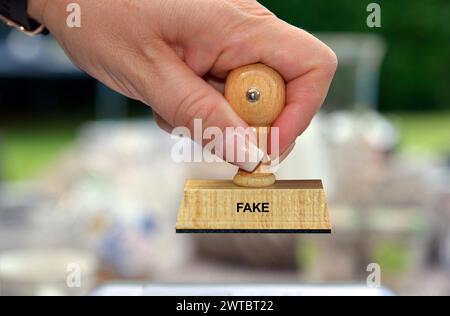 Symbolfoto, weibliche Hand mit Stempel, Inschrift: Fake, Studio Stockfoto