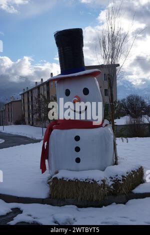 Nahaufnahme eines Schneemanns aus Heuballen in der Stadt embrun, alpen, frankreich im Winter an einigen Gebäuden Stockfoto