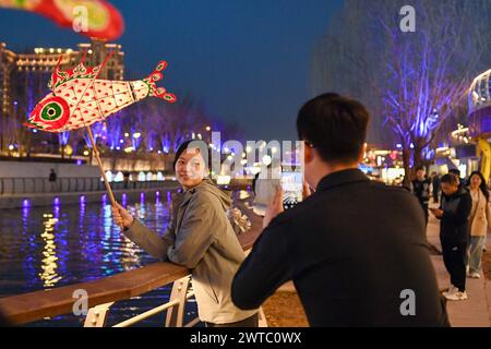 (240317) -- PEKING, 17. März 2024 (Xinhua) -- Touristen genießen sich entlang des Liangma-Flusses in Peking, Hauptstadt Chinas, 16. März 2024. Am Samstag fand in Peking eine Förderveranstaltung des Liangma-Flusses statt. Der Fluss Liangma durchquert verschiedene Bereiche, darunter ausländische Botschaften, internationale Hotels, Kaufhäuser und trendige Geschäftsstraßen, die verschiedene internationale Geschäftsviertel in Peking miteinander verbinden. 2019 begann der Stadtteil Chaoyang ein Projekt am Ufer des Liangma River. Nach zwei Jahren Entwicklung und Verbesserung der Umwelt, die Liangm Stockfoto