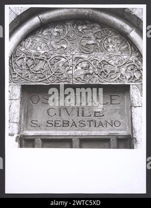 Lazio Viterbo Capranica portale romanico. Hutzel, Max 1960-1990 Mittelalter: Architektur, Architekturskulptur. Dieses Portal (heute Teil der Ospedale Civile) stammt aus dem 13. Jahrhundert. Die Lünette des Portals ist mit einem Weinrollmotiv verziert, in dem monströse halbmenschliche und halb tierische Figuren verschlungen sind. Der in Deutschland geborene Fotograf und Gelehrte Max Hutzel (1911–1988) fotografierte in Italien von den frühen 1960er Jahren bis zu seinem Tod. Das Ergebnis dieses Projektes, von Hutzel als Foto Arte Minore bezeichnet, ist eine gründliche Dokumentation der kunsthistorischen Entwicklung in Italien bis zum 18. Jahrhundert, einschließlich Stockfoto