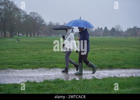 London, Vereinigtes Königreich 17 März 2024 . Wanderer halten sich heute Morgen mit Regenschirmen auf dem Wimbledon Common im Südwesten Londons. Credit: amer ghazzal/Alamy Live News Stockfoto