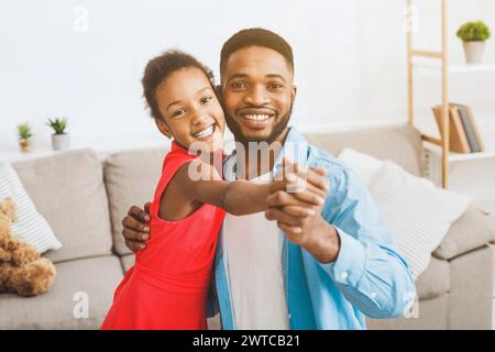 Schöner Vater und süße Tochter tanzen zu Hause Stockfoto