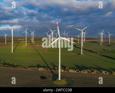 Petersdorf, Deutschland. März 2024. Die niedrige Abendsonne scheint auf die Windräder des Windparks „Odervorland“ (Luftbild mit einer Drohne aufgenommen). Quelle: Patrick Pleul/dpa/Alamy Live News Stockfoto