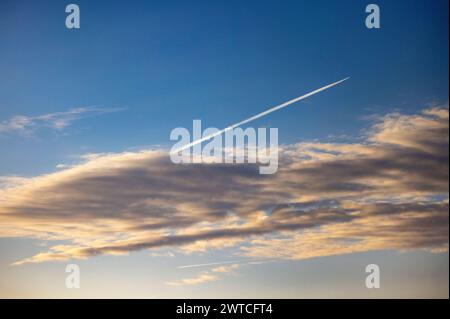 17. März 2024, Nordrhein-Westfalen, Königswinter: Ein Flugzeug hinterlässt Kondensstreifen am blauen Himmel. Foto: Thomas Banneyer/dpa Stockfoto