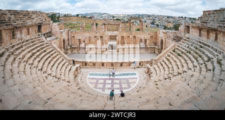 Jerash, Jordanien - 5. Mai 2022: Ein malerischer Blick auf das majestätische antike römische Amphitheater in Jerash, Jordanien, bei dem Besucher die historischen Ruinen erkunden. Stockfoto