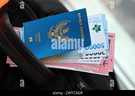 Blue Republic Indonesien Pass mit Geld und Flugtickets auf touristischen Rucksack Nahaufnahme. Tourismus und Reisekonzept Stockfoto