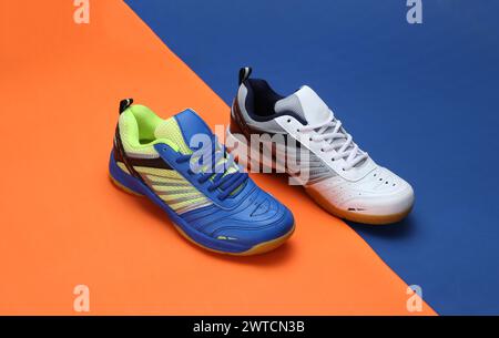 Badmintonschuhe mit kreativem Foto auf orangeblauem Hintergrund Stockfoto