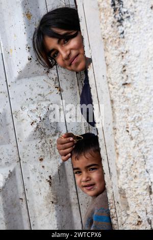 Bilin, Ramallah, Palästina. Dezember 2010 31. Palästinensische Kinder stehen am 31. Dezember 2010 bei wöchentlichen Demonstrationen am Freitag gegen die Besetzung palästinensischer Gebiete durch Israel in Bilin, Westjordanland, Palästina, vor ihrer Tür. Bilin, ein kleines Dorf in der Nähe von Ramallah, findet wöchentlich Proteste statt, da ein Großteil des Landes der Bauern von den israelischen Behörden annektiert wurde, um eine neue jüdische Siedlung zu bauen. (Credit Image: © Dominika Zarzycka/SOPA images via ZUMA Press Wire) NUR REDAKTIONELLE VERWENDUNG! Nicht für kommerzielle ZWECKE! Stockfoto