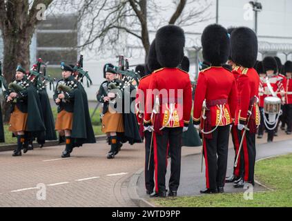 Mons Barracks, Aldershot, Hampshire, Großbritannien. März 2024. Das Regiment der Irish Guards versammelt sich in einer speziellen St. Patrick's Day Parade und Feier in Aldershot. Die Parade ist ein Höhepunkt des Jahres für dieses duale Regiment, das seine irischen kulturellen Wurzeln bewahrt. Die Parade besteht aus dem 1st Battalion Irish Guards, der No. 9 Company Irish Guards, der No. 12 Company Irish Guards, der Band of the Irish Guards, Reserven der No. 15 (Loos) Company Irish Guards (The London Guards), Veteranen und Kadetten der Irish Guards, und die unnachahmlichen Pfeifen der irischen Garde und das Regimental Irish Wolfhound Mascot, Stockfoto