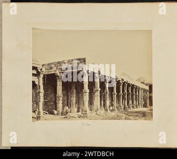 Delhi. John Edward Saché, Fotograf (preußisch oder britisch, geb. Preußen, 1824–1882) 1864–1868 Ansicht einer Kolonnade aus aufwändig geschnitzten Steinsäulen, Teil des Qutb-Minar-Komplexes. Ein Mann steht gegen eine der Säulen. (Recto, Halterung) unten links, in Bleistift: 'A48.28'; unten in der Mitte, in Bleistift: 'Delhi'; Stockfoto