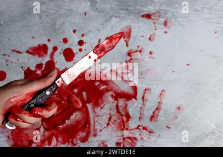 Blutige Hand mit Messer auf weißem Hintergrund, Draufsicht. Suizidkonzept Halloween-Thema: Blutige Hand mit Messer. Stockfoto