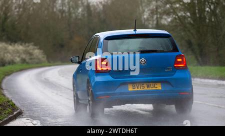 Milton Keynes, UK-Mar 17th 2024: 2015 blaues Volkswagen Polo Auto fährt im Regen Stockfoto