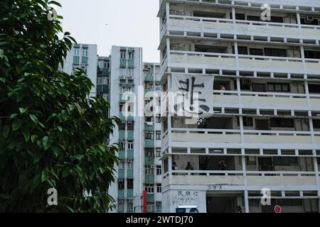 Hongkong, China. März 2024. Auf dem Tai Hang Sai Estate wird ein Banner mit dem chinesischen Schriftzeichen „miserable“ angezeigt. Das 1965 erbaute Tai Hang Sai Estate war ursprünglich als Wohnraum für Bewohner konzipiert, die durch die Räumung des Tai Hang Sai Resettlement Area vertrieben wurden. Mit mehr als 1.600 Einheiten unter den marktüblichen Preisen ist es Hongkongs einziges privates, niedrig vermietetes Wohngebiet. Derzeit sind Pläne für den Abriss und die Sanierung des Anwesens geplant, deren Fertigstellung für 2029 veranschlagt wird. Bei der Sanierung werden voraussichtlich mehr als 3.300 Einheiten zur Verfügung stehen. (Kreditbild: © Stockfoto