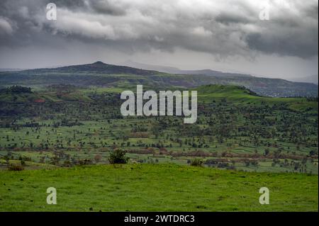Landschaft der Regenzeit. Monsunwolken bedeckten den Himmel und Hügel mit grünem Gras, das die Landschaft grün macht. Stockfoto