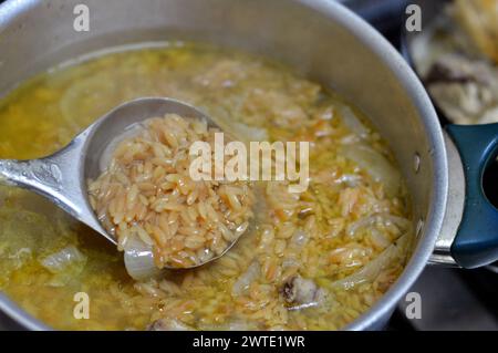 Nahöstliche ägyptische Pasta-Suppe, auch bekannt als Shorbet Lesan El Asfour, traditionelle ägyptische Komfortgerichte aus Orzo Pasta, Butter und Oliven Stockfoto