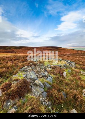 Eine rekonstruierte bronzezeitliche Siedlung am Ilkley Moor in Yorkshire. Die Siedlung besteht aus einem Hüttenkreis und Mauern. Stockfoto