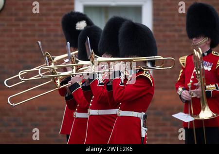 Mons Barracks, Aldershot, Hampshire, Großbritannien. März 2024. Das Regiment der Irish Guards versammelt sich in einer speziellen St. Patrick's Day Parade und Feier in Aldershot. Die Parade ist ein Höhepunkt des Jahres für dieses Zweirollen-Regiment. Lady Ghika, Ehefrau des Regimentsleutnant Colonel, Major General Sir Christopher Ghika, überreicht Shamrock an Offiziere, Seamus und Haftbefehler, die es wiederum entlang der Reihen ausstellen. Die Parade endet mit einem vormarsch, bei dem der Oberstleutnant des Regiments, Generalmajor Sir Christopher Ghika, den Gruß abnimmt. Kredit: Malcolm Park/Alamy Stockfoto