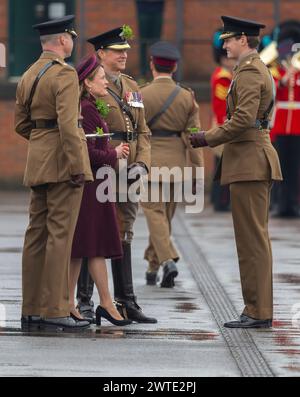 Mons Barracks, Aldershot, Hampshire, Großbritannien. März 2024. Das Regiment der Irish Guards versammelt sich in einer speziellen St. Patrick's Day Parade und Feier in Aldershot. Die Parade ist ein Höhepunkt des Jahres für dieses Zweirollen-Regiment. Lady Ghika, Ehefrau des Regimentsleutnant Colonel, Major General Sir Christopher Ghika, überreicht Shamrock an Offiziere, Seamus und Haftbefehler, die es wiederum entlang der Reihen ausstellen. Die Parade endet mit einem vormarsch, bei dem der Oberstleutnant des Regiments, Generalmajor Sir Christopher Ghika, den Gruß abnimmt. Kredit: Malcolm Park/Alamy Stockfoto