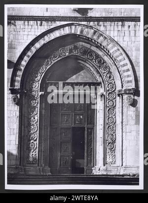 Umbrien Perugia Todi SS. Annunziata, Duomo. Hutzel, Max 1960-1990 mittelalterliche Kernkollektion: Außen- und Innenansicht dieses Bauwerks aus dem 12. Bis 16. Jahrhundert. Die Außenfotos umfassen die drei Rosenfenster, die architektonische Skulptur der Apsis und der Langhaumwände, den Glockenturm und einen Skulpturenkopf in einem Rundlauf mit Inschrift. Der Blick auf das Innere, das 1958 restauriert wurde, konzentriert sich auf die Kapitelle des Kirchenschiffs (um 1270), die größtenteils korinthianisch sind. Zwischen den Akanthus einiger Pier-Kapitelle befinden sich Skulpturen, darunter St. Peter, St. Paul, St. Michael, Christus und die Jungfrau mit dem Heiligen Geist Stockfoto