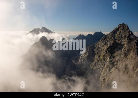 Panoramablick vom Gipfel der Hohen Tatra in der Slowakei Rysy im nebeligen Sommermorgen. Höchster Gipfel Gerlach bedeckt von Wolken im Hintergrund Stockfoto