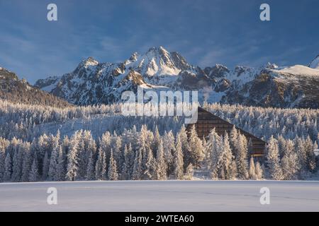 Beliebtes Hotel in Strbske pleso, hohe Tatra, Slowakei. Gefrorener See im Vordergrund mit Letterspace, sonw bedeckte Berge und Bäume im Rücken Stockfoto