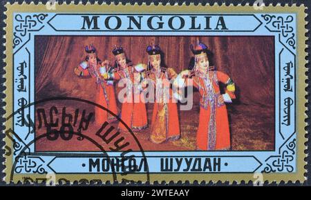 Von der Mongolei gedruckte Briefmarke, die Volkstänze zeigt, um 1987. Stockfoto