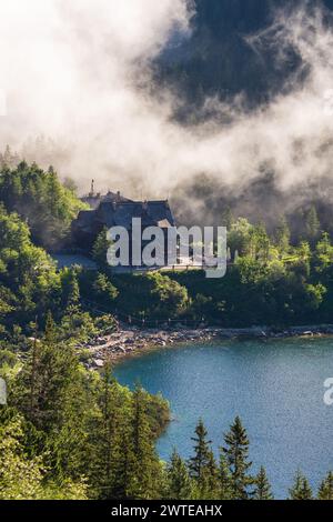 Berghütte in Tatra mit Nebel im Hintergrund am Morskie Oko See. Sehr beliebtes Touristenziel in Polen. Wunderschöner Ort in den Tatra Bergen. Stockfoto