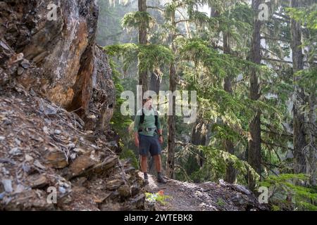 Man wandert um Rock Cliff auf dem Hoh River Trail im Olympic National Park Stockfoto