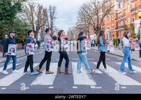 Abbey Road, London, Großbritannien. März 2024. Schüler der israelischen High School, Überlebende des Terroranschlags vom 7. Oktober 2023, die London als Teil einer Delegation besucht haben, die vom Human Chain Project 7/10 organisiert wurde, gehen über den von den Beatles berühmten Abbey Road-Übergang, halten Geiselplakate ihrer sieben Freunde und Nachbarn. in Gaza immer noch gefangen gehalten, seit sie vor 163 Tagen während eines palästinensischen Angriffs in Israel aus ihren Häusern genommen wurden. Die Gruppe besuchte Studenten in London, um ihre Geschichten und schrecklichen Erfahrungen des Massakers zu teilen. Phot: Amanda Rose/Alamy Live News Stockfoto