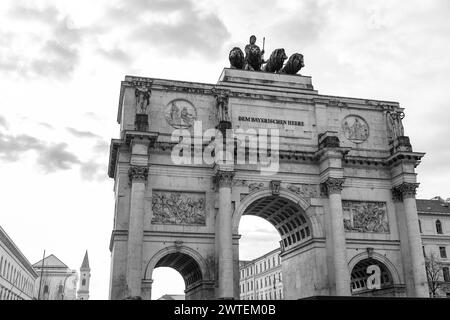 Der Siegestor, das Siegstor in München, ist ein dreigewölbter Gedenkbogen, gekrönt von einer bayerischen Statue mit einem Löwenquadriga. Stockfoto