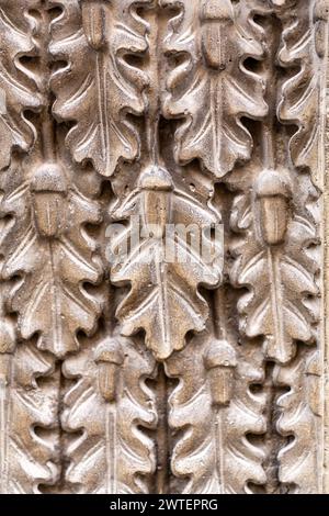 Detail aus einem Wandschmuck mit Eichenblättern und acord in Stein gemeißelt, architektonisches Fragment einer alten europäischen Mauer Stockfoto