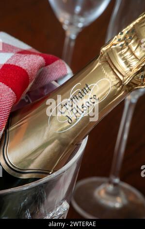 Cremant d'Alsace Sektflasche im Eiskübel mit Gläsern dahinter am französischen Esstisch. Elsass Frankreich Stockfoto