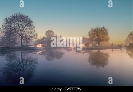 RIVER WEY DAWN NEBEL SONNENAUFGANGSLANDSCHAFT Papercourt Lock auf einem immer noch nebligen perfekten herbstlichen Sonnenaufgang, mit einem Boot Crew-Mitglied, das die Schleusentore am River Wey Surrey in Großbritannien bedient Stockfoto