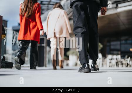 Eine Niedrigwinkelaufnahme, die die modischen Schuhe zweier Personen einfängt, die in einer urbanen Umgebung an einander vorbeilaufen, und die Bewegung und das Leben in der Stadt veranschaulicht. Stockfoto