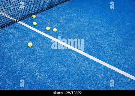 Fünf Bälle in der Nähe des Netzes auf einem blauen Paddle-Tennisplatz Stockfoto