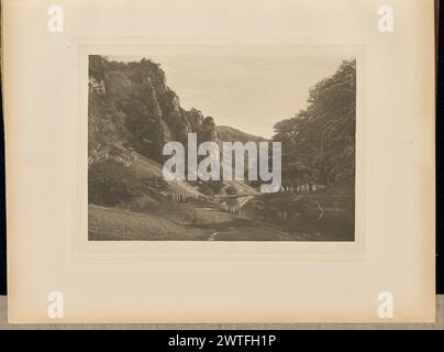 In Dove Dale. Captain George Bankart, Fotograf (Britisch, 1829 - 1916) 1888 Blick auf Dovedale und die umliegenden Berge. Mehrere Holzpfosten stehen in einem Bruch in einer Steinmauer, die durch den Talboden neben dem River Dove schneidet. Die Initialen des Fotografen, „GB“, wurden in die untere linke Ecke des Bildes eingekratzt. (Recto, angrenzendes Interleaving) Mitte, gedruckt in schwarzer Tinte: 'PLATE XLII. IN DOVE DALE.“ Stockfoto