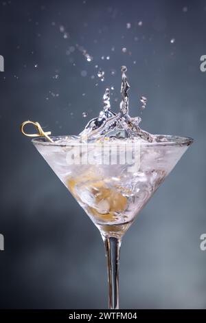 Mit Blaukäse gefüllte Oliven in einem Wodka-Martini mit Wodka-Spritzern überall Stockfoto