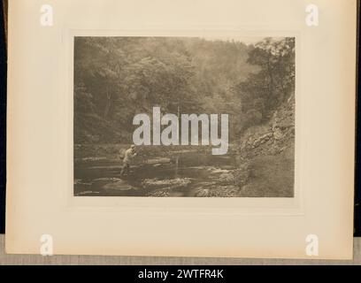 In Dove Dale. „Habet!“. Captain George Bankart, Fotograf (Britisch, 1829 - 1916) 1888 Blick auf einen Mann, der beim Angeln knöcheltief in der River Dove steht. Er trägt einen Korb, um Fische auf dem Rücken zu halten, während er mit einer straffen Angelschnur kämpft. (Recto, angrenzendes Interleaving) Mitte, gedruckt in schwarzer Tinte: 'PLATTE XXXVIII. IN DOVE DALE. „HABET!“ Stockfoto