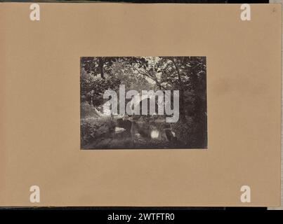 Cromwell's Bridge, Glengarriff. Wahrscheinlich Sir John Joscelyn Coghill, Fotograf (Irisch, 1826–1905), etwa 1860–1870 zwei junge Männer, die auf einem Felsen am Rande eines Flusses sitzen. Die Ruinen einer Steinbogenbrücke überqueren den Fluss. Bäume bedecken die umliegende Landschaft. (Recto, Halterung) oben rechts, Bleistift: '61'; Stockfoto
