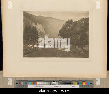 Eintritt zu Dove Dale, Derbyshire. Captain George Bankart, Fotograf (Britisch, 1829 - 1916) 1888 Blick auf Dovedale im Peak District. Der River Dove durchschneidet das Tal mit zwei kleinen Wasserfällen, die sich nahe beieinander am Fluss befinden. Die Initialen des Fotografen, „GB“, wurden in die untere rechte Ecke des Bildes eingekratzt. (Recto, angrenzendes Interleaving) Mitte, in schwarzer Tinte gedruckt: 'PLATE XXXVII. EINTRITT ZUM DOVE DALE, DERBYSHIRE." Stockfoto