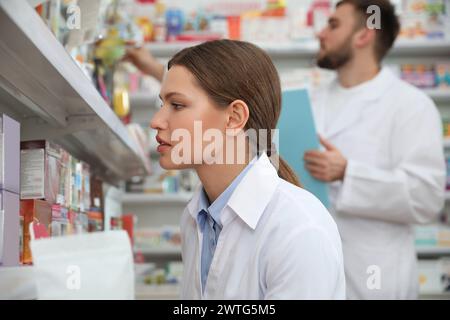 Fachapotheker in der Nähe von Regalen in einer modernen Apotheke Stockfoto