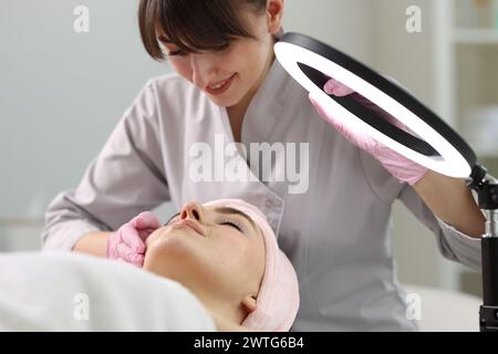 Kosmetikerin, die Gesichtsmassage für Klienten in der Klinik macht Stockfoto