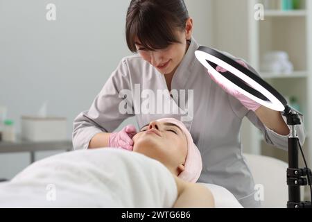 Kosmetikerin, die Gesichtsmassage für Klienten in der Klinik macht Stockfoto