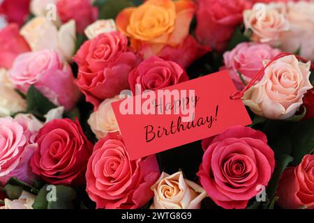 Blumenstrauß mit schönen Rosen mit Happy Birthday Karte, Nahaufnahme Stockfoto