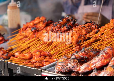 Satay oder Sate ist ein südostasiatischer Döner, der aus gewürztem, spießtem und gegrilltem Fleisch mit einer Sauce zubereitet wird. Stockfoto