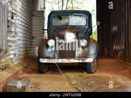 Ein alter verprügelter Truck in der verwitterten Scheune in Ga Stockfoto