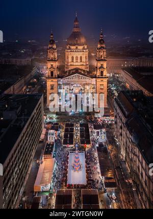 Budapest, Ungarn - aus der Vogelperspektive auf Europas schönsten Weihnachtsmarkt am beleuchteten Stephansdom. Eislaufbahn, Weihnachtsbaum und Klon Stockfoto