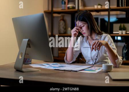 Die junge Frau arbeitet zu Hause bis spät in die Nacht Stockfoto