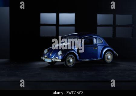 Blaues Vintage-Miniaturauto auf dunklem Hintergrund Stockfoto