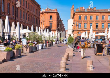 Toulouse Haute Garonne Frankreich 03.13.24 Place du Capitole. Markttag. Speisen im Freien. Große historische Backsteingebäude. Bögen und Geschäfte. Steinbalu Stockfoto